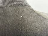 the back of a gray sweater with a small white dot on it