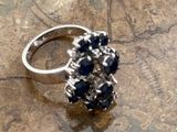 a silver ring with blue stones in it on a table
