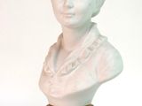 un buste de femme en marbre blanc posé sur un socle noir