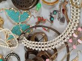 many different types of necklaces and bracelets laid out on a table