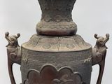 a large vase with a bird on it on a stand