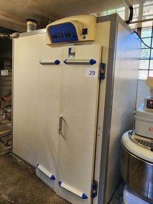 a large white refrigerator in a kitchen with a lot of clutter