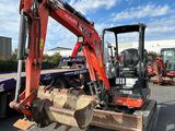 a red excavator that is sitting in the parking lot