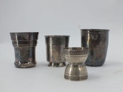 three silver cups are sitting next to each other on a white surface