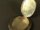 a small silver box with a mirror on a table