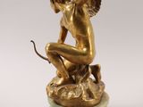 an antique bronze statue of a cupid holding a bow on a marble base