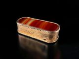 an image of a gold and red box sitting on top of a black surface