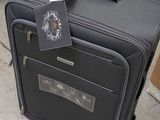 a piece of luggage sitting on the ground with a tag attached to it