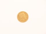 a close up of a gold coin on a white surface