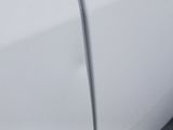 a close up of a white car with a black emblem on it