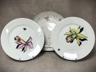 trois assiettes ornées de fleurs, posées sur une table