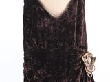 the dress is made of velvet and has a large bow at the waist