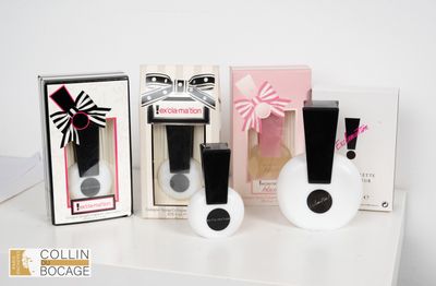 trois flacons de parfum et une boîte posés sur une table blanche
