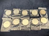 six gold coins in clear plastic bags on a black surface
