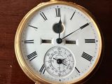 une montre de poche en or avec des chiffres romains sur le cadran