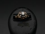 a close up of a gold and diamond ring on a black surface