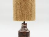 a close up of a lamp on a white surface with a brown shade