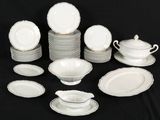 a lot of white plates and bowls on a black table