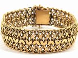 a close up of a gold bracelet on a white background