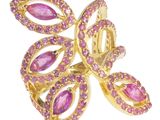 un gros plan d'une bague ornée de pierres roses sur fond blanc
