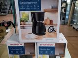 trois cartons contenant des machines à café posés sur une table dans un magasin