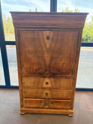 une commode en bois devant une grande fenêtre