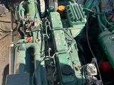 a large green engine sitting in the middle of a pile of junk
