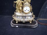 a gold clock sitting on top of a marble base