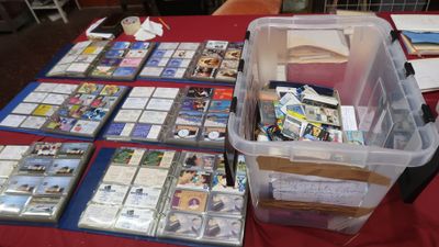 a lot of cards on a table with a bin of them