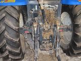 a blue tractor that is parked in the dirt
