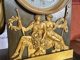 a gold clock sitting on top of a marble table