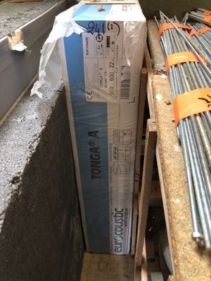 une pile de tuyaux métalliques posée dans une pièce