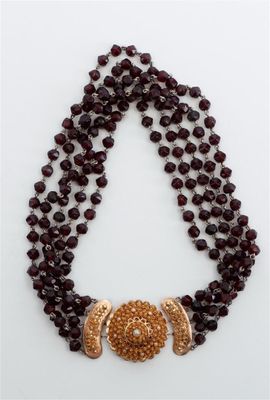 un gros plan d'un collier orné de perles sur un fond blanc