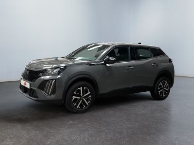 un SUV gris garé dans une pièce aux murs blancs