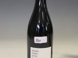 a bottle of wine sitting on a table next to a glass of wine