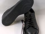pair of black leather sneakers with laces on them on a white surface