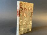an old book sitting on top of a table next to a gray wall