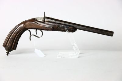 un vieux fusil exposé sur une surface blanche