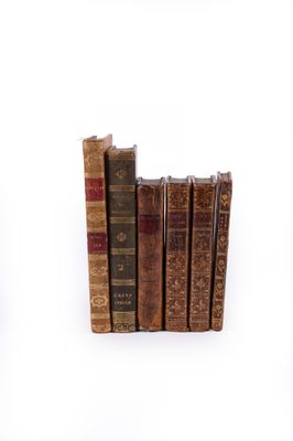 plusieurs vieux livres sont empilés sur une surface blanche
