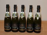 six bouteilles de champagne sont alignées sur une table
