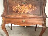 a small wooden table with a floral design on it