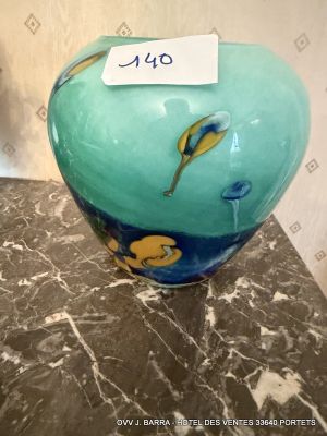 a blue vase with a tag on it sitting on a table