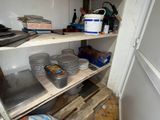 many plates and pans on the shelves in the kitchen