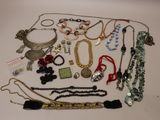 many necklaces and bracelets laid out on a table