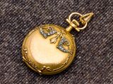 une petite montre de poche en or ornée d'un oiseau