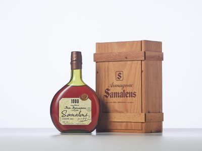a bottle of brandy sitting next to a wooden box