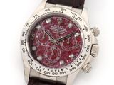 an image of a wrist watch with a red dial and brown leather strap