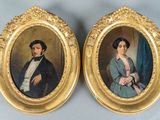pair of portraits of a man and a woman in a gold frame