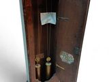 a wooden grandfather clock with a pendulum hanging from it ' s side