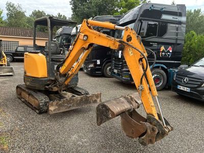 une petite excavatrice garée sur un parking